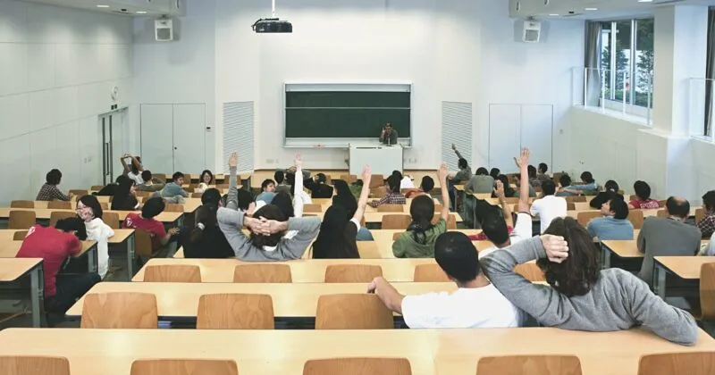 University classroom with engineering students raising their hands during a lecture